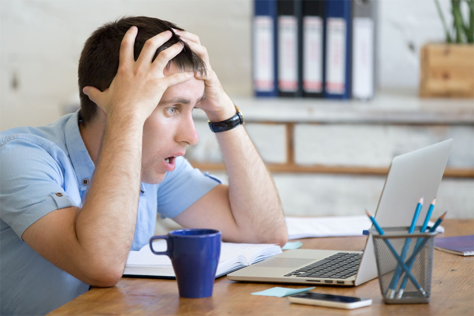 Man Looking at Laptop Worried